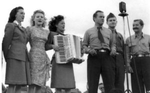 Frances Langford (in lfowered dress) Bob Hope (center near microphone) and Jerry Colonna (right with moustache) at a USO show sometime in 1945. Photo credit www.eaglehorse.org
